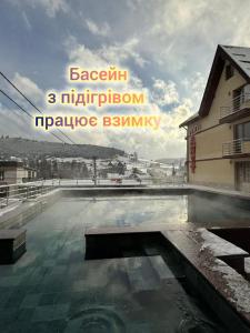 een grote plas water voor een gebouw bij Villa Anet in Boekovel