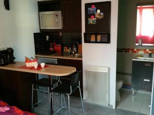 una pequeña cocina con mesa y fregadero en Petit studio au calme, en La Crau