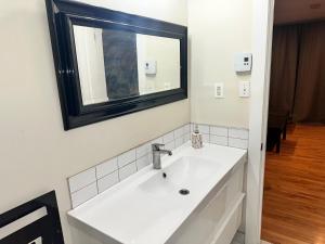 un bagno bianco con lavandino e specchio di Appartement meublé 2ch - Verone 6 a Laval Altre 8 foto