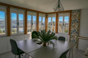 a dining room with a table and chairs and windows at Beachfront Surf & Holiday House, Charming & Quiet in Valdoviño