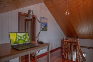 a laptop computer sitting on a table with a lamp at Beachfront Surf & Holiday House, Charming & Quiet in Valdoviño