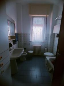 a bathroom with two toilets and a sink and a window at Lara home in Gaglianico