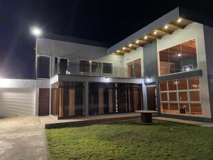 a house at night with a bench in front of it at Villa Oasis Antananarivo Private Stay in Antananarivo