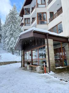 a snow covered building with awning in front of it at Dream Apart - Iceberg in Pamporovo