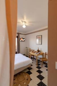 a hotel room with a bed and a table at Hôtel Restaurant Sole e Monte in Cuttoli-Corticchiato