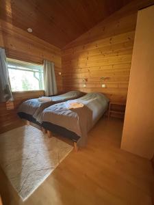a bedroom with two beds in a log cabin at Loma-aika in Vierumäki