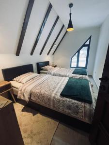 two beds in a room with a window at Ćilibar Stara planina in Crni Vrh