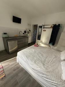 a bedroom with a large bed and a kitchen at Loft Mouly in San Sebastián de la Gomera