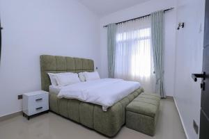 a bedroom with a large bed and a large window at Matanak 2 in Munyonyo