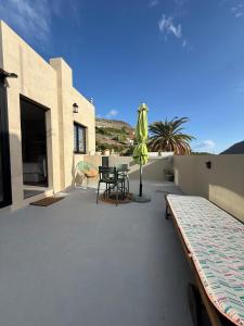 a patio with a table and a umbrella at Loft Mouly in San Sebastián de la Gomera