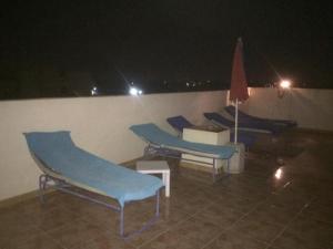 a group of blue chairs on a roof at night at Sphinx in Al Karnak