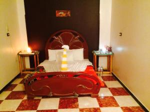 a bedroom with a large bed with a wooden headboard at Sphinx in Al Karnak