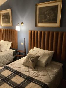 una camera da letto con un letto con testiera e cuscini di La Dimora di Luca a Bientina