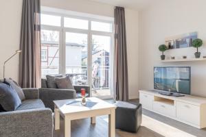 a living room with a couch and a tv at Villa Marin, Wohnung 16 in Zinnowitz