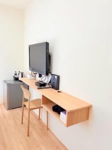 een bureau met een computermonitor en een stoel bij Jian Guo Hotel in Pingtung City