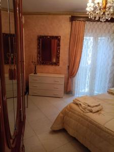 una camera da letto con un letto, uno specchio e una cassettiera di Appartamento centro storico quartiere San Michele a Sciacca