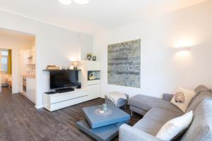 a living room with a couch and a tv at Villa Marin, Wohnung 04 in Zinnowitz