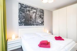 een slaapkamer met een wit bed met rode handdoeken erop bij Villa Marin Wohnung 04 in Zinnowitz