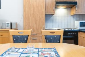 a kitchen with a wooden table and two chairs at Haus Roland, Wohnung 02 in Zinnowitz