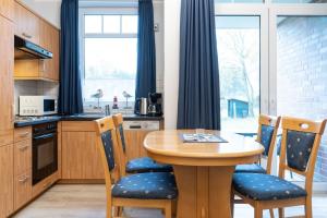 a kitchen with a wooden table and chairs at Haus Roland, Wohnung 02 in Zinnowitz