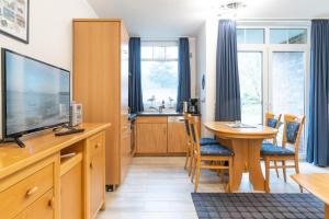 a living room with a television and a dining room table at Haus Roland, Wohnung 02 in Zinnowitz