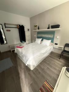 a bedroom with a white bed and a wooden floor at Loft Mouly in San Sebastián de la Gomera +8 photos