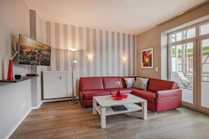 a living room with a red couch and a table at Villa Marin, Wohnung 14 in Zinnowitz
