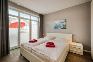a bedroom with two beds with red pillows on them at Villa Marin, Wohnung 14 in Zinnowitz +14 photos