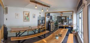a room with two wooden benches and a kitchen at Hostel Kuntur in Puerto Natales