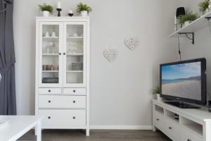 a white cabinet with a television in a living room at Villa Marin, Wohnung 17 in Zinnowitz