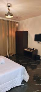 een slaapkamer met een wit bed en een tv bij Naturehunt homestays in Kodaikānāl