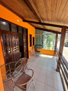 a patio with chairs and tables and a wooden ceiling at Casa Fácil in Itacaré +15 photos
