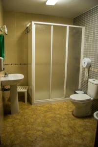 a bathroom with a shower and a toilet and a sink at Pension Carretero in Cáceres