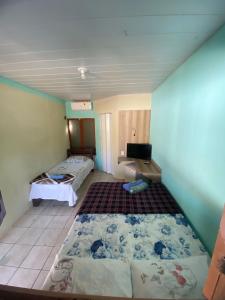 a room with two beds and a tv in it at Pousada Encantos de Paripueira in Paripueira +34 photos