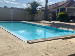 a large blue swimming pool in a yard at Villa Oasis Antananarivo Private Stay in Antananarivo