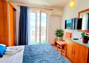 een slaapkamer met een bed en een groot raam bij Apartmani Skoric Fanatic in Primošten