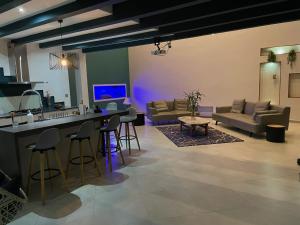 a living room with a bar with chairs and a couch at Villa Oasis Antananarivo Private Stay in Antananarivo