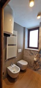 a bathroom with a toilet and a sink and a window at Valtour House in Valtournenche +11 photos