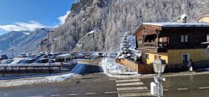 a parking lot with cars parked on the side of a mountain at Valtour House in Valtournenche