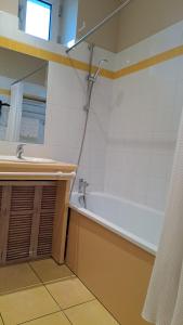 un bagno con vasca e lavandino di eurl l'ABRICOTIER a Saint-Macaire Altre 5 foto