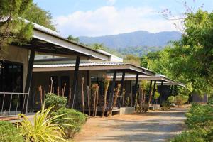 a building with trees in front of it at บ้านสราญรัตน์ in Ban On Luai