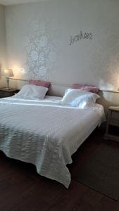 una camera da letto con un grande letto bianco con lenzuola bianche di eurl l'ABRICOTIER a Saint-Macaire