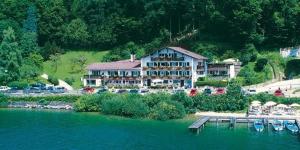 a large building on the shore of a lake at Hotel Fischerstüberl am See in Tegernsee