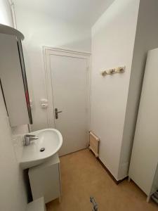 a white bathroom with a sink and a door at Apartment with exceptional views in Saint-Nazaire +14 photos