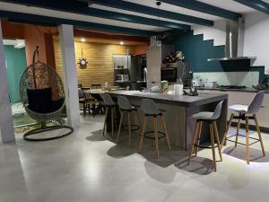 a kitchen with a large island with bar stools at Villa Oasis Antananarivo Private Stay in Antananarivo