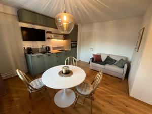 un soggiorno con tavolo, sedie e divano di Apartment Laura a Jenig Altre 22 foto