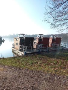 a group of boats sitting on a dock on the water at Kleines Hausboot - ideal für Ihren Angelurlaub! in Lychen