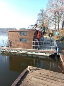 a house boat parked at a dock on the water at Kleines Hausboot - ideal für Ihren Angelurlaub! in Lychen