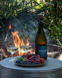 a bottle of wine and two glasses on a table at WA Wilderness Camping Experience in Pemberton