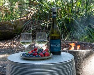 a bottle of wine and two glasses on a barrel at WA Wilderness Camping Experience in Pemberton +23 photos